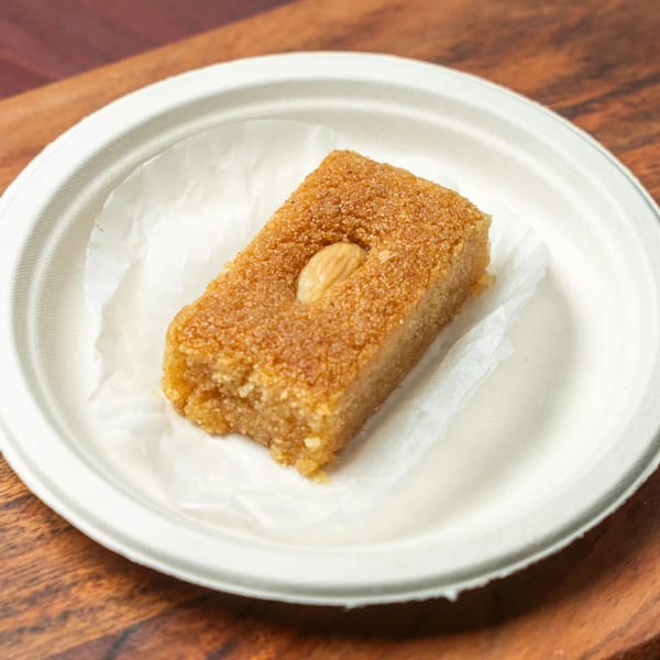 Hovan Gourmet Mediterranean's semolina cake with an almond on top, served on a white plate.