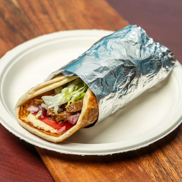 Hovan Gourmet Mediterranean wrap, partially unwrapped from foil, on a white plate.